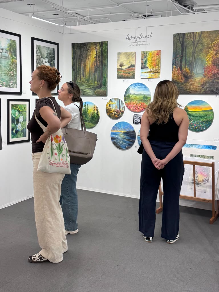 Guests viewing round and framed artworks at an exhibition