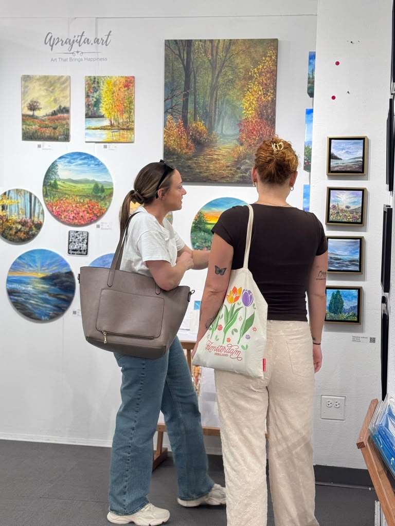 Two visitors looking at colourful circular artworks
